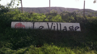 Panneau d'entrée sur le site du Village.